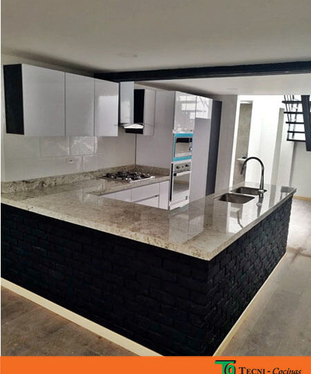 Cocina moderna abierta en forma de U con combianción de colores entre beige, negro y blanco de doble poceta con estufa a gas en color negro