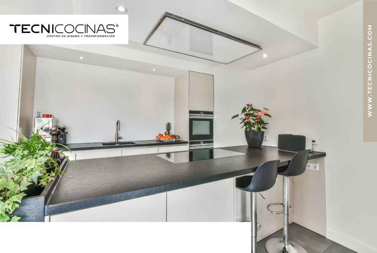 Cocina abierta con extractor de techo discreto, sin estructuras visibles sobre la isla.