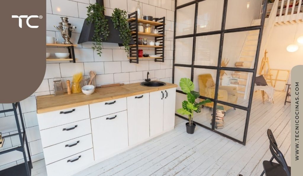 Cocina en línea con cerramiento de cristal y perfiles negros separando el área de estar