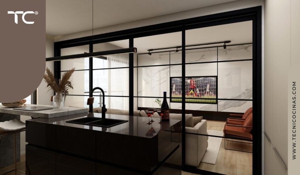 Cocina con isla oscura y cerramiento de vidrio con perfilería negra vista desde el interior