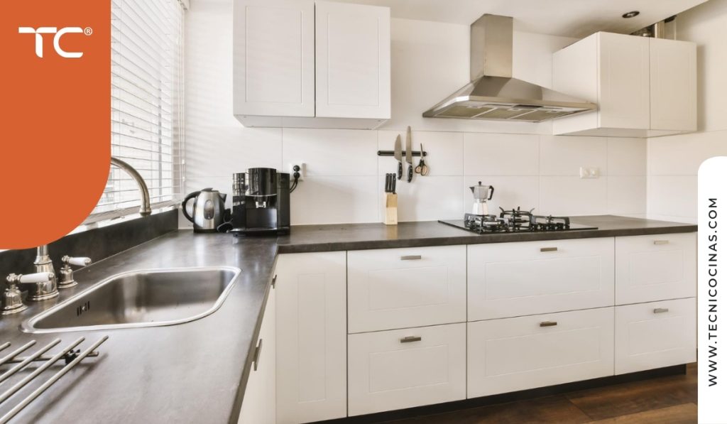 Cocina con gabinetes blancos y campana extractora en acero inoxidable