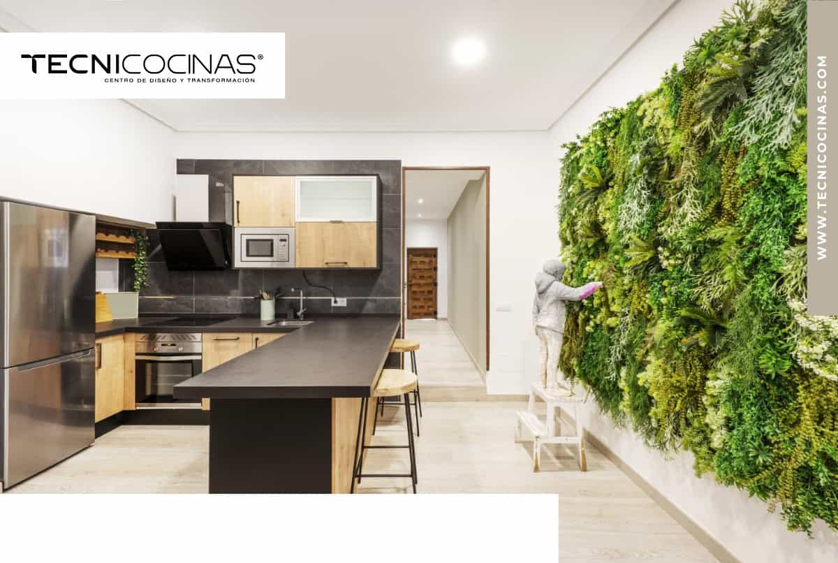 Cocina moderna con muro verde de plantas naturales y mobiliario en madera clara