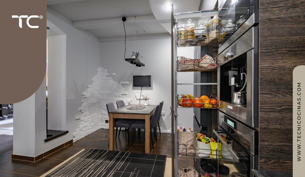 Columna extraíble de despensa con canastas metálicas fuera del mueble junto a hornos empotrados