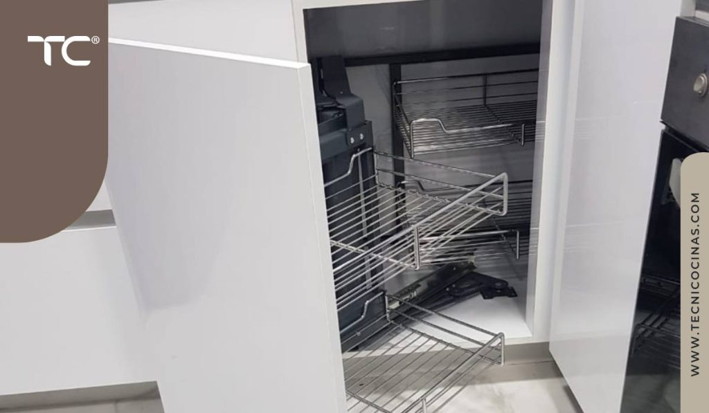 Gabinete de esquina con canastilla metálica extraíble instalada en cocina integral blanca