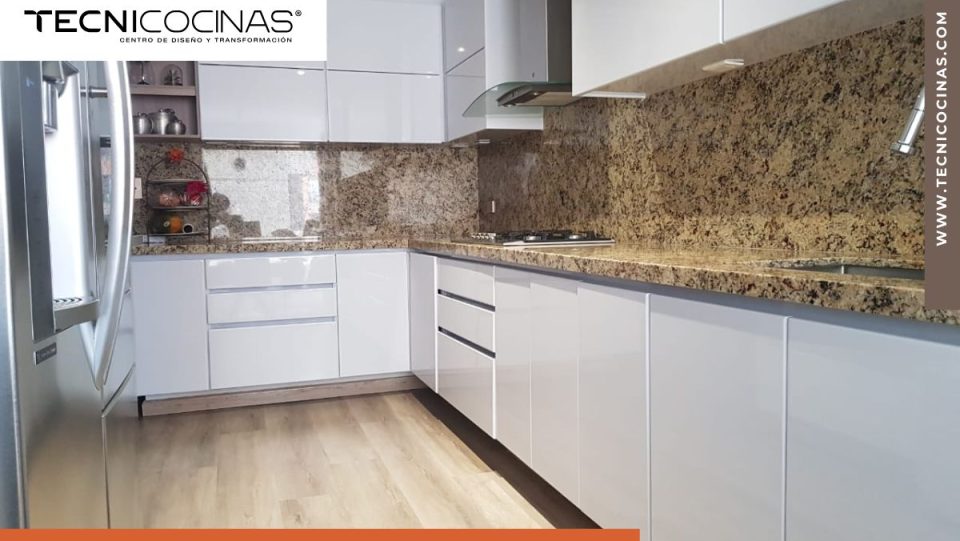 Cocina integral en L con mesón de granito y gabinetes blancos, esquina donde se instala el herraje giratorio