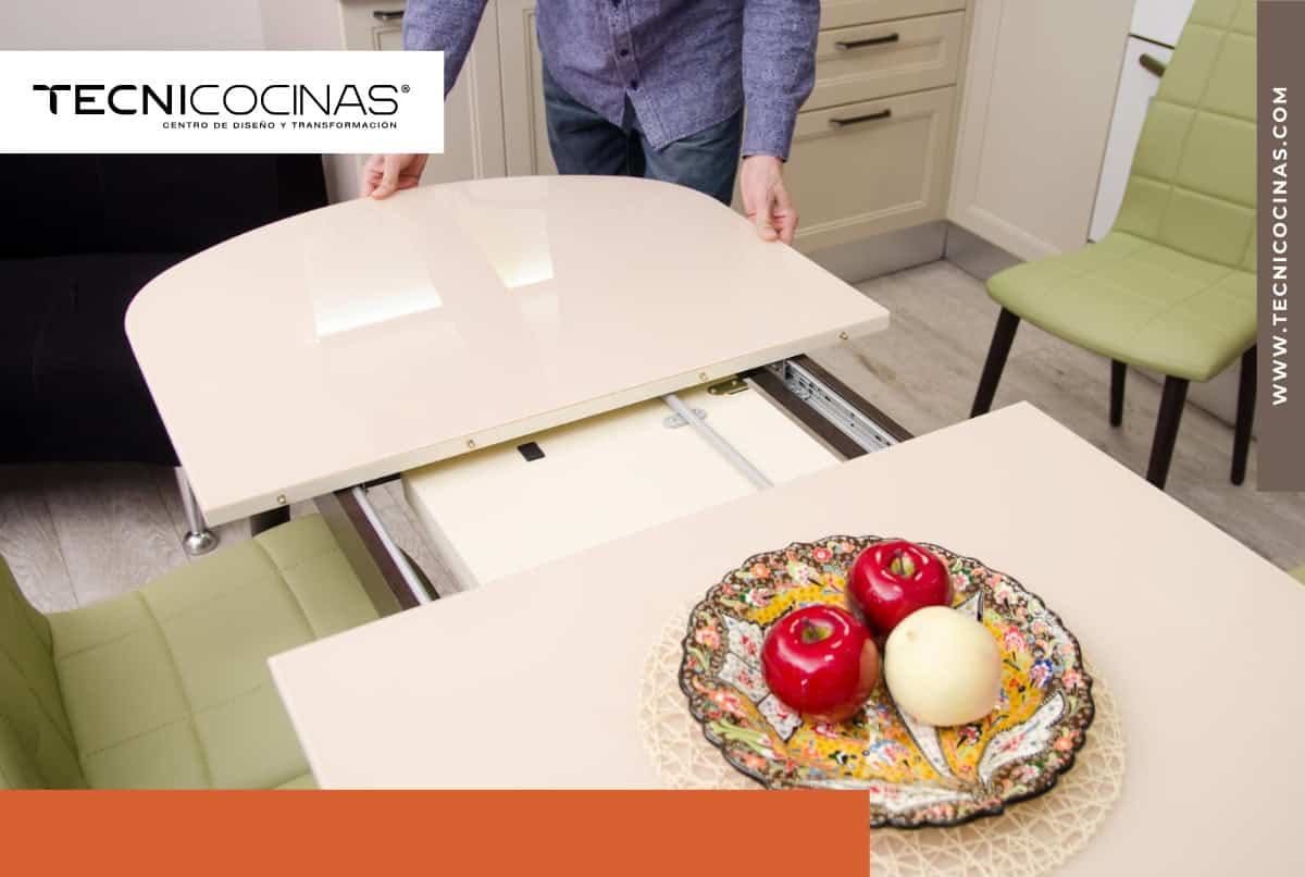 Mesa extensible blanca con sistema telescópico en cocina moderna mostrando mecanismo de apertura central