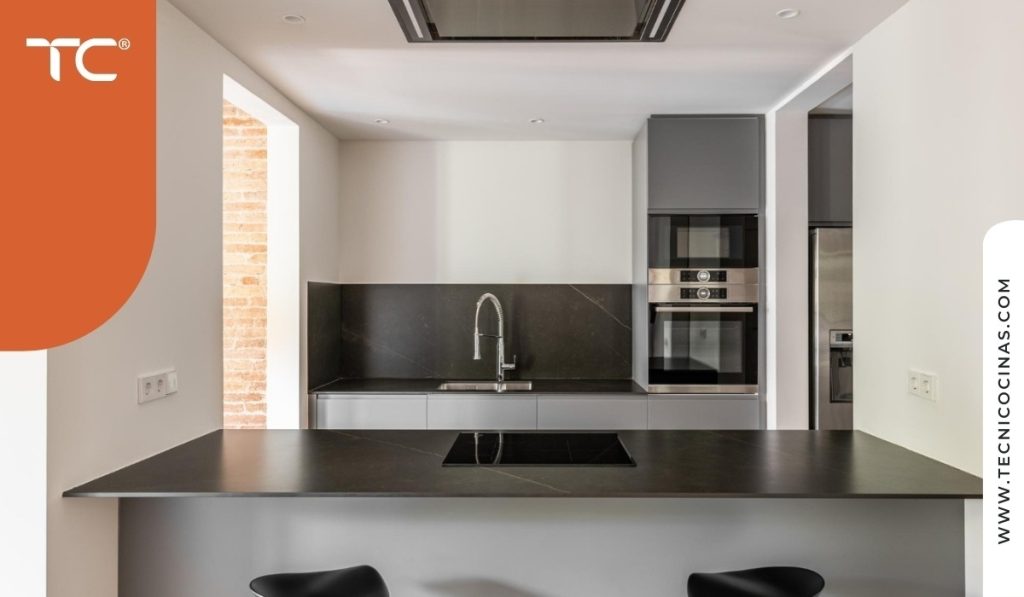 Mesón de cocina en piedra sinterizada oscura con perfil ultrafino de 12mm instalado en isla mostrando resistencia y diseño contemporáneo
