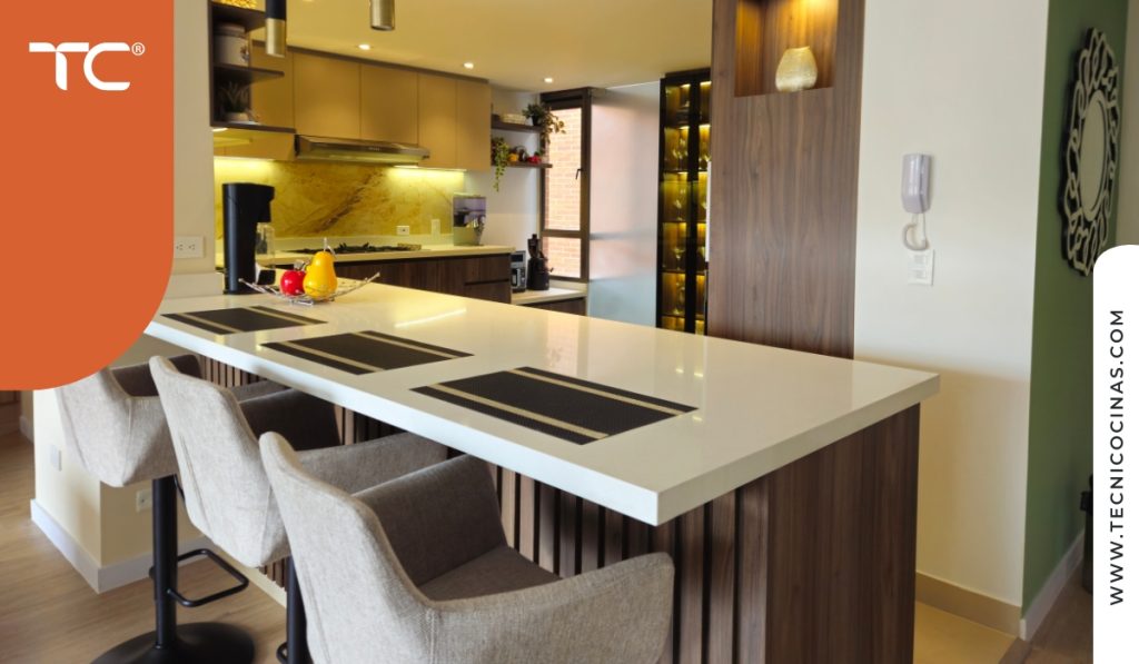 Cocina integral con barra desayunadora en apartamento de Bogotá, espacio de circulación limitado