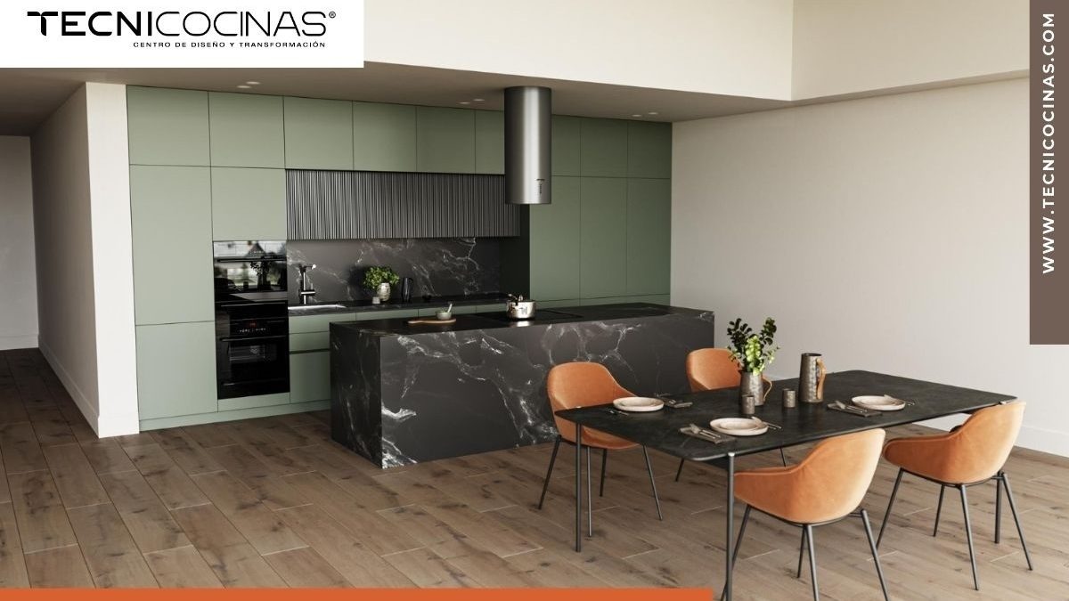 Cocina moderna con gabinetes color verde salvia, isla y backsplash de mármol negro veteado, comedor integrado con sillas tapizadas en terracota y piso de madera - Tecnicocinas