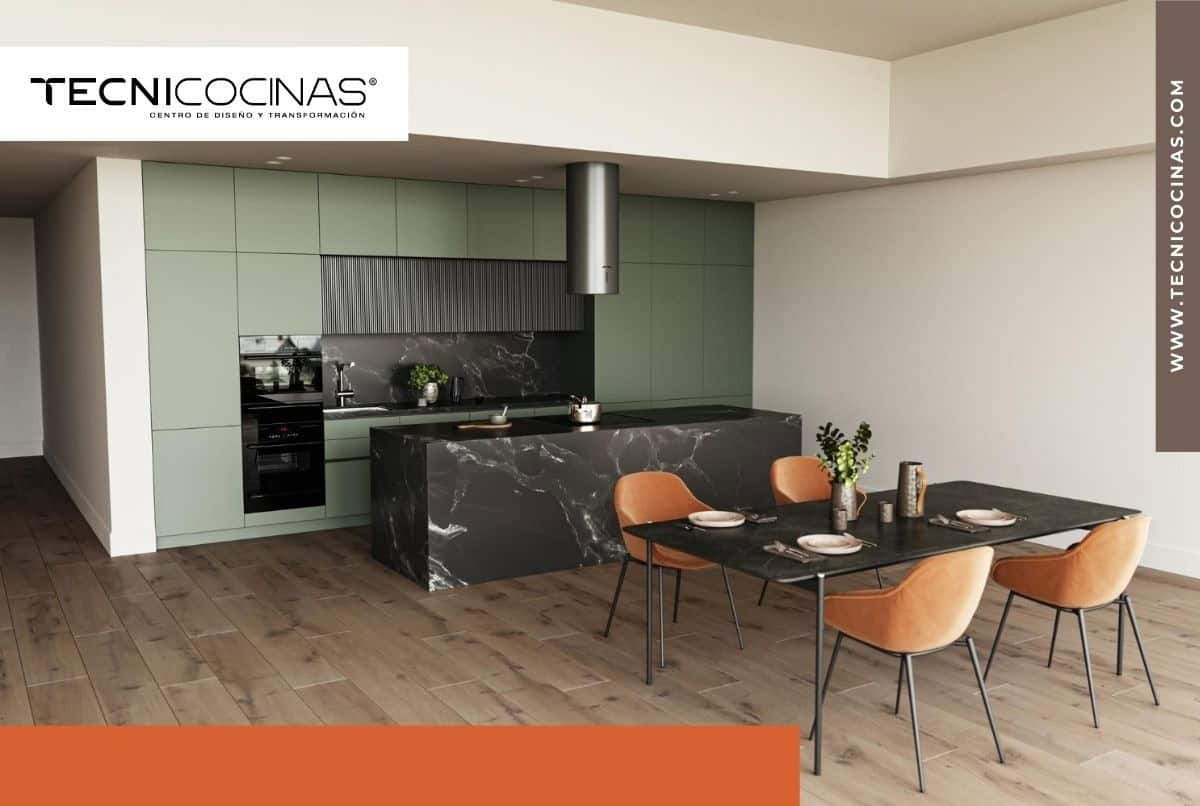 Cocina moderna con gabinetes color verde salvia, isla y backsplash de mármol negro veteado, comedor integrado con sillas tapizadas en terracota y piso de madera - Tecnicocinas