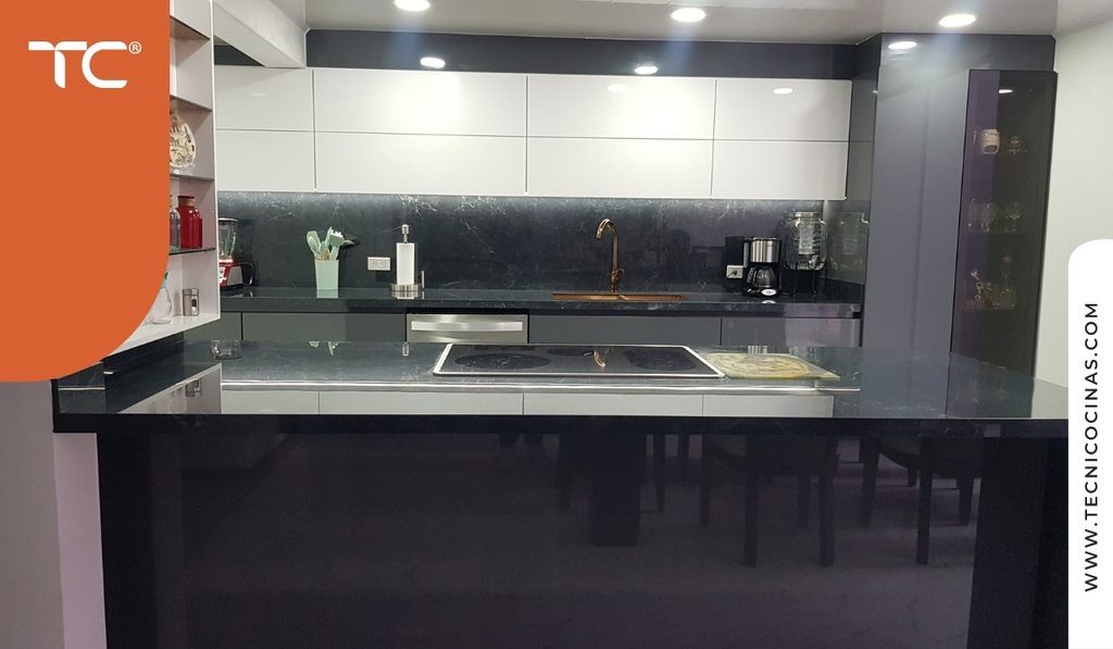 Módulo alto con puerta de vidrio ahumado y perfil negro en una cocina de frentes gris claro