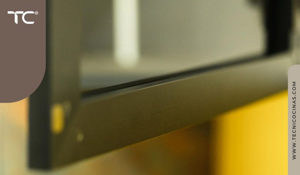 Detalle del marco y perfil de una puerta de vidrio ahumado en cocina